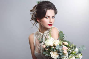 灰色背景下的時尚發(fā)型和化妝微笑新娘肖像