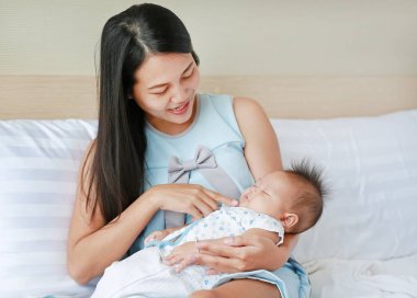 母亲在床房里抱着熟睡的婴儿 母亲在床房里抱着熟睡的婴儿