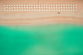 空中的顶视图，在海滩上。遮阳伞、 沙滩和大海的波浪