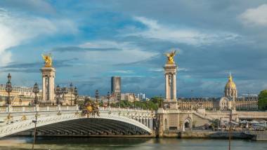 亚历山大三世大桥横跨河围网游戏中时光倒流。装饰着华丽的艺术灯具和雕塑。查看从路堤。巴黎。法国。蓝多云的天空，在日落之前