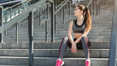 坐在楼梯上的疲惫的年轻女子图片