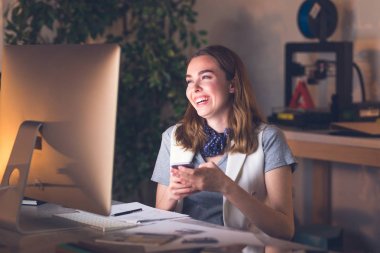 美丽的微笑的白种商人晚上坐在办公室里, 拿着她的手机 美丽的微笑的白种商人晚上坐在办公室里, 拿着她的手机