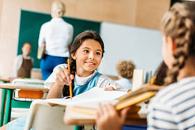 快乐的小女生在课上和同学聊天