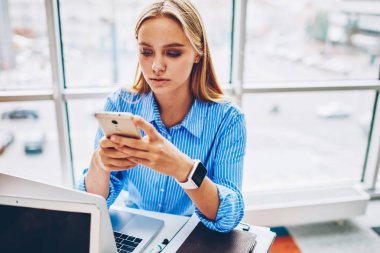 嚴重的女企業(yè)家檢查電郵信箱在智能手機短信反饋當花費時間在辦公室, 女實業(yè)家使用智能手機在銀行網(wǎng)上交易的應(yīng)用