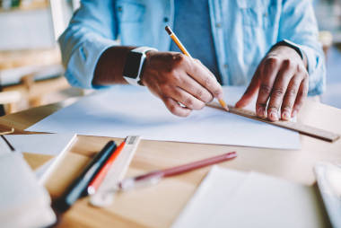 裁剪圖象的建筑師的手與 smartwatch 持有鉛筆和素描草圖的建筑藍(lán)圖在白皮書?；谠O(shè)備的木質(zhì)桌面設(shè)計(jì)跟蹤規(guī)劃