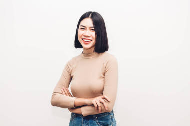 年輕的亞洲婦女模特微笑和擺出白色背景