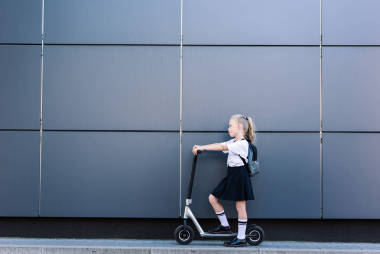 可爱的小女生的侧面, 长卷曲的头发骑摩托车在街上