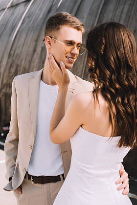 幸福典雅的新婚夫妇拥抱和看着对方在城