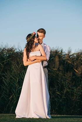 快乐温柔的年轻新婚夫妇拥抱和微笑在公园里 