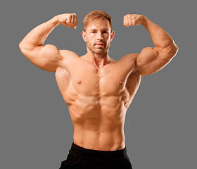 年轻英俊健美男子摆出肌肉的外