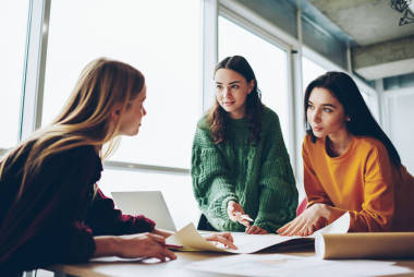 嚴(yán)肅的高加索婦女小組建筑師討論戰(zhàn)略和解決方案一起檢查素描和起草, 在辦公室合作工作過程中巧妙的女船員集思廣益