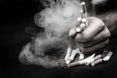 動機銘文戒煙, 不健康的習慣。在黑色的背景下, 用煙霧把香煙滅掉。黑白照片