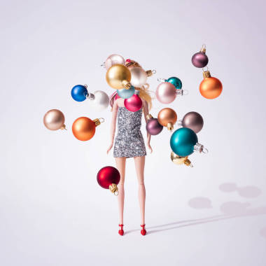 女孩玩偶在銀色閃閃發(fā)光的禮服與多彩的圣誕節(jié)華而不實(shí)裝飾, 創(chuàng)造性的極小的時(shí)尚概念