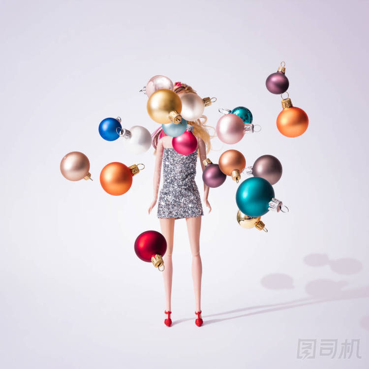 女孩玩偶在銀色閃閃發(fā)光的禮服與多彩的圣誕節(jié)華而不實(shí)裝飾, 創(chuàng)造性的極小的時(shí)尚概念