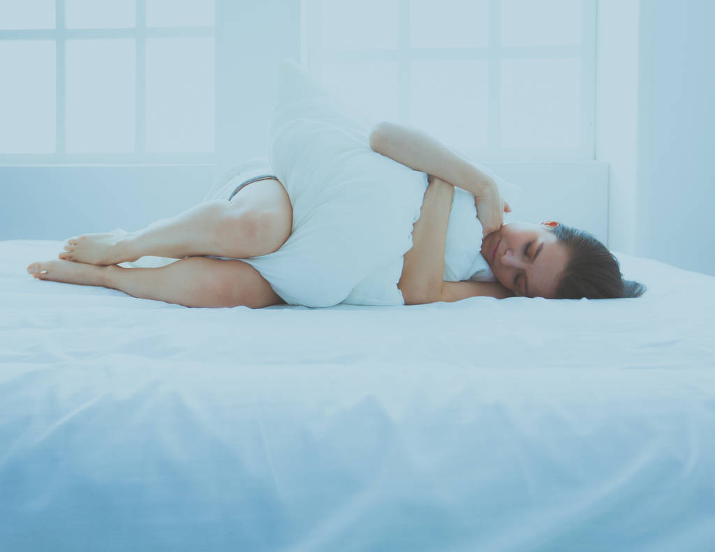 年轻女性在床上感到疼痛