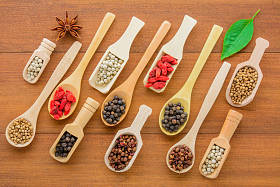 各种干草药 (干粒) 在木勺上, 不同种类的干草药在木勺空间上放在木桌上。健康营养食品概念