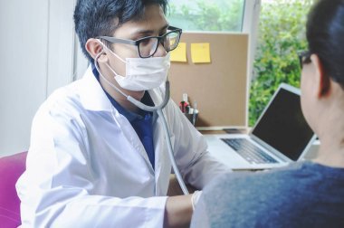 醫(yī)生檢查她的脈搏男醫(yī)生在病房檢查女性病人。婦科健康在醫(yī)療診所或醫(yī)院保健服務(wù)中心的應(yīng)用