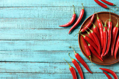 紅色成熟辣椒在板材和藍(lán)色木桌上的高的看法