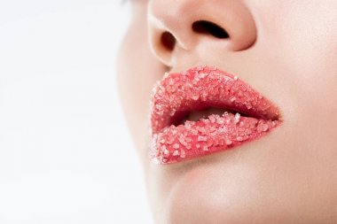 在粉红色的嘴唇上的妇女与糖的裁剪视图, 在白色隔离