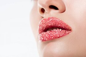 在粉红色的嘴唇上的妇女与糖的裁剪视图, 在白色隔离