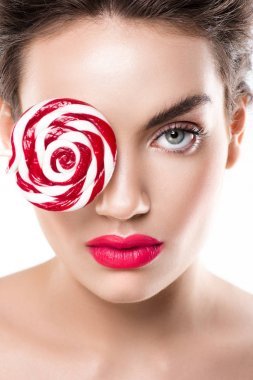 美麗的時(shí)尚女孩手持紅色棒糖在眼前, 孤立的白色