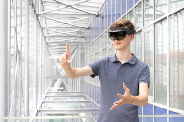 现代建筑中使用增强现实全息透镜的年轻白种青少年画像。各种手势和空气水龙头控制的护目镜.