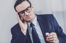 患偏头痛的患病商人照片