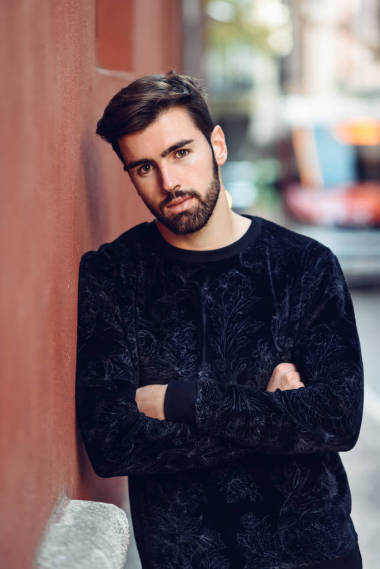 年輕的大胡子男子, 時裝模特, 看著相機在城市背景穿著休閑服裝。街上有胡子和時髦發(fā)型的家伙