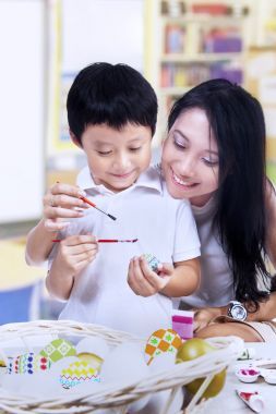 美麗的母親教兒子如何畫復(fù)活節(jié)彩蛋