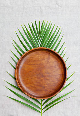 用棕榈叶天然亚麻纺织背景上的木板。复制空间。顶视图