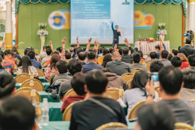 觀眾的后方視圖顯示手回答問題從演講人在會議大廳或研討會會議、商業(yè)和教育概念的階段