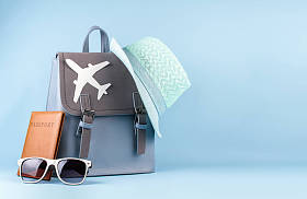 女性时尚旅游背包带护照和帽子在蓝色背景下