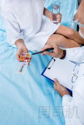 老年男性醫(yī)生用聽診器指著醫(yī)院病房女性病人的圖像