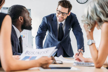 在辦公室開(kāi)會(huì)時(shí)坐在桌邊的年輕多族裔商人