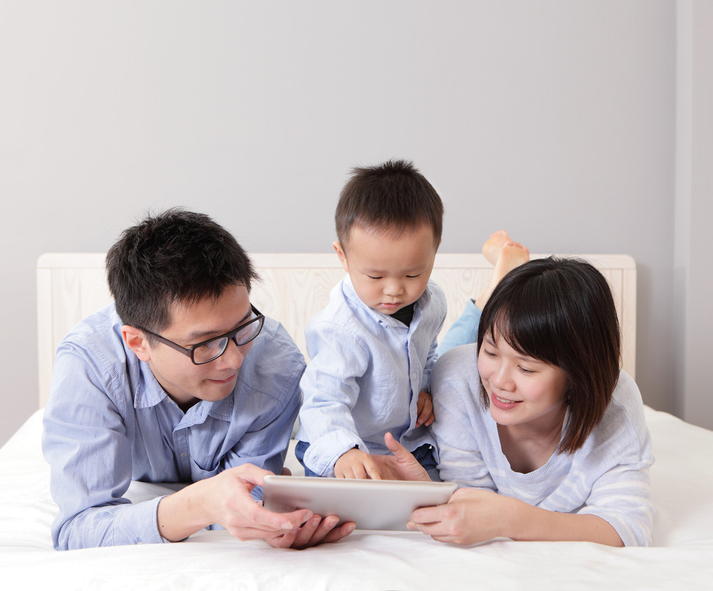 与幸福的家庭使用 tablet pc 的可爱男孩 与幸福的家庭使用 tablet pc 的可爱男孩