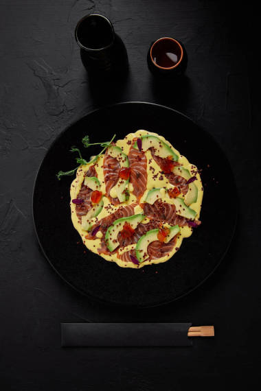 在黑盤子上的美食日本菜與切片魚和鱷梨醬