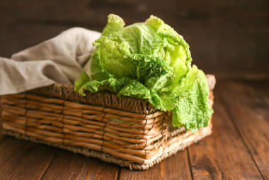 木桌上有新鮮熟卷心菜的柳條籃