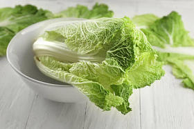 新鲜熟卷心菜碗在轻的木桌上图片