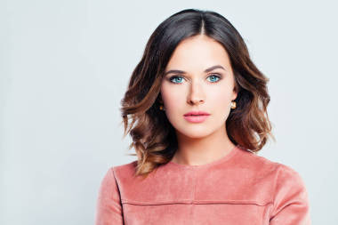 優(yōu)雅的女人黑發(fā)與卷曲的頭發(fā)和化妝白色橫幅背景, 時(shí)尚肖像