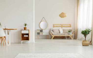 鏡子在白色內(nèi)閣旁邊在米色木沙發(fā)在客廳內(nèi)部與植物。真實(shí)照片