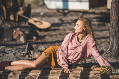 嬉皮女孩休息在毯子與菠蘿附近拖車在自然