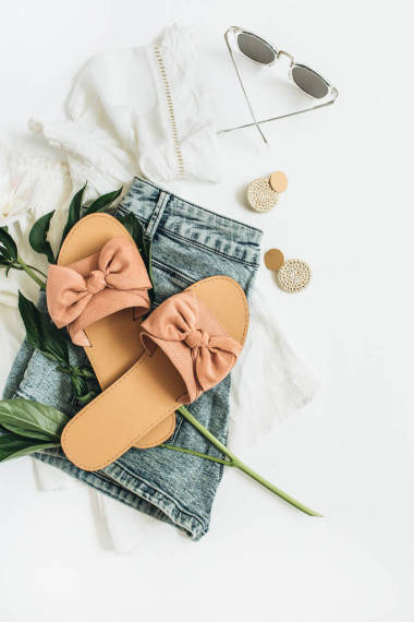 女性时尚背景与白色牡丹花, 拖鞋, 太阳镜, 耳环, 短裤, t恤衫。平躺, 顶视图美女或时尚博客概念