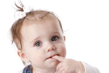 用她的手指在她的嘴微笑白種人女嬰