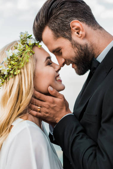 婚紗夫婦的肖像和白色禮服觸摸海灘上的鼻子