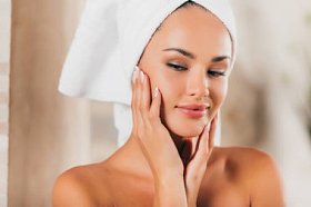 华丽的女人在浴袍与完美干净的脸