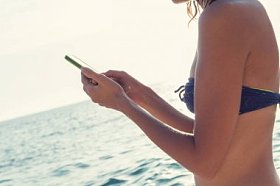 小女孩在海边用手机