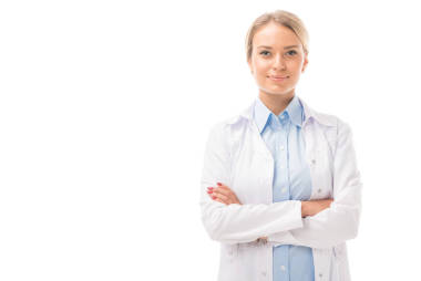自信的年輕女醫(yī)生與交叉的武器看著相機(jī)在白色隔離