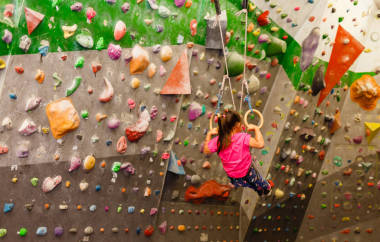 穿著運動服的小女孩在體育館的墻上做運動戒指的練習(xí)。健康生活方式的概念從年輕的年齡。兒童運動