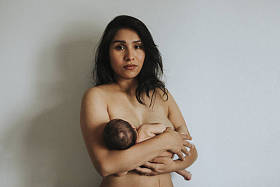 赤裸的母亲抱着她的新生婴儿