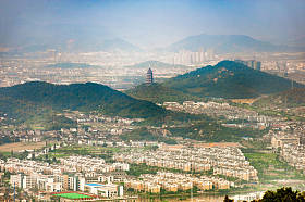 多云天山上的佛塔对城市景